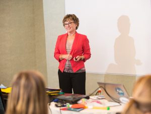 Lori Frost, co-developer of PECS, standing and presenting a workshop